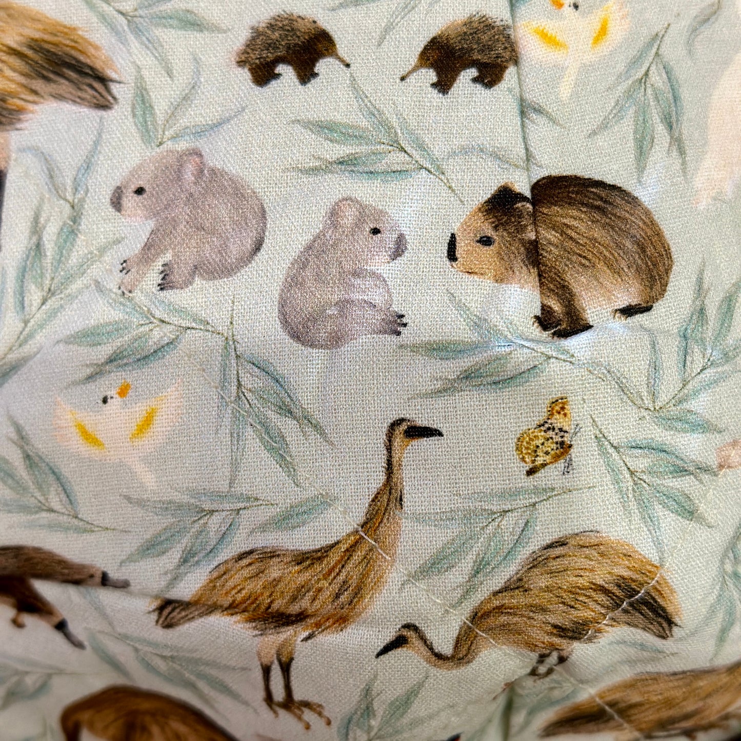 Close up of Australian animal fabric bowl cosy with emu, wombat, echidna, cockatoo and koala