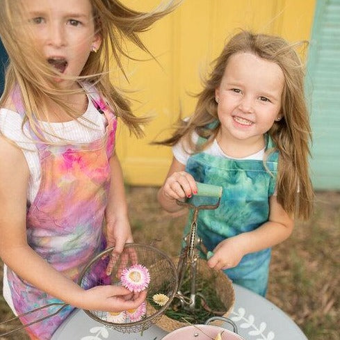 Two sisters wearing ice dyed aprons while playing cooking games