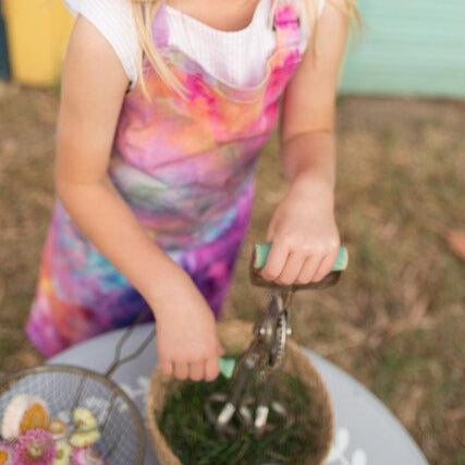Child in an ice dyed colourful apron while playing cooking games