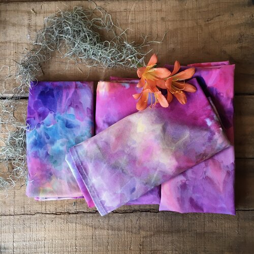 A pile of ice dyed aprons in rainbow colours