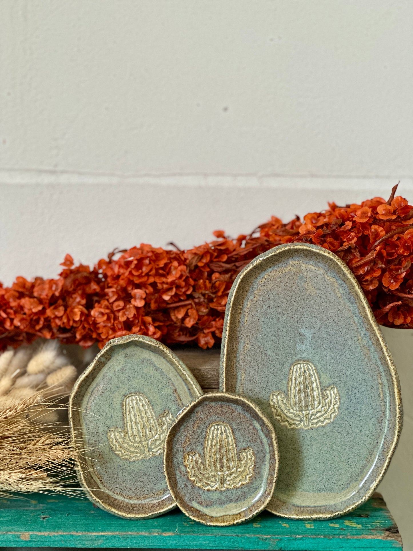 Set of three handmade ceramic dishes featuring a banksia design