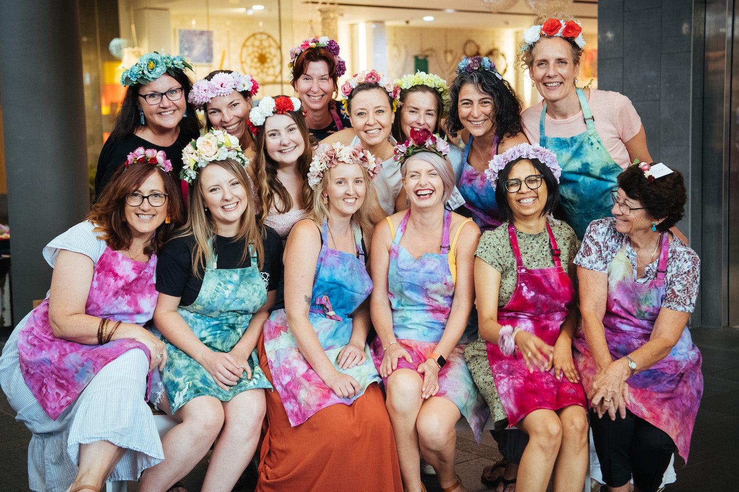 14 women wearing ice dyed colourful aprons